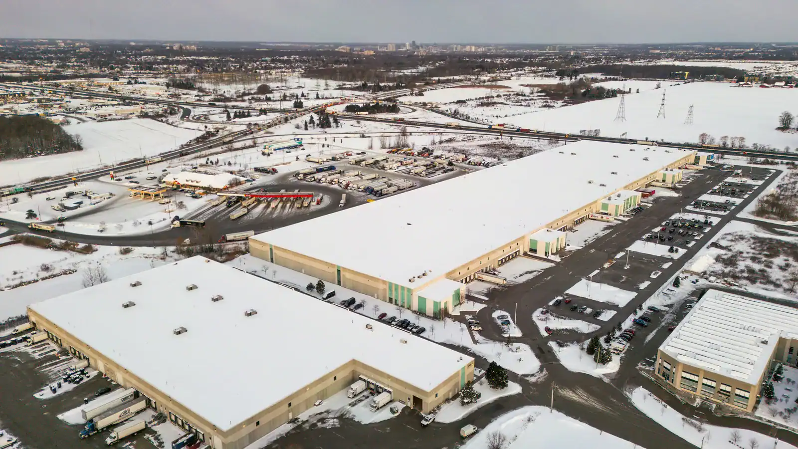 Aerial view of large warehouse buildings with snow-covered roofs