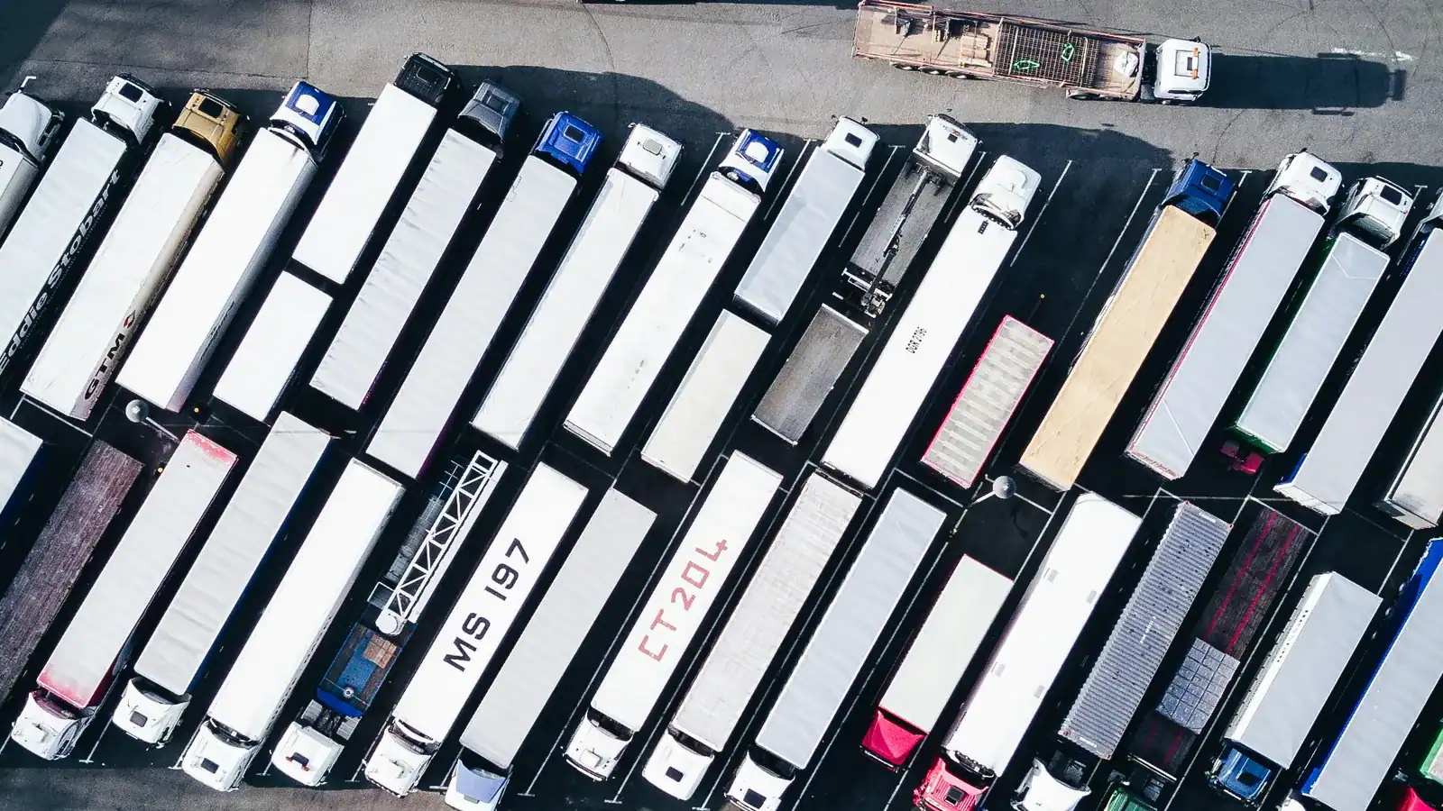 Aerial view of freight trucks and trailers in a parking lot