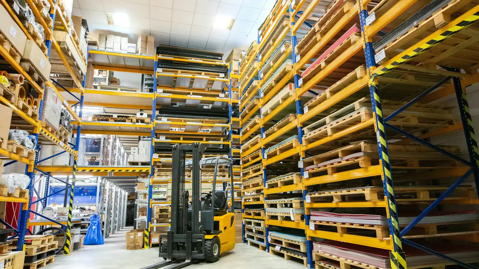 Warehouse aisles of pallet racking with a forklift