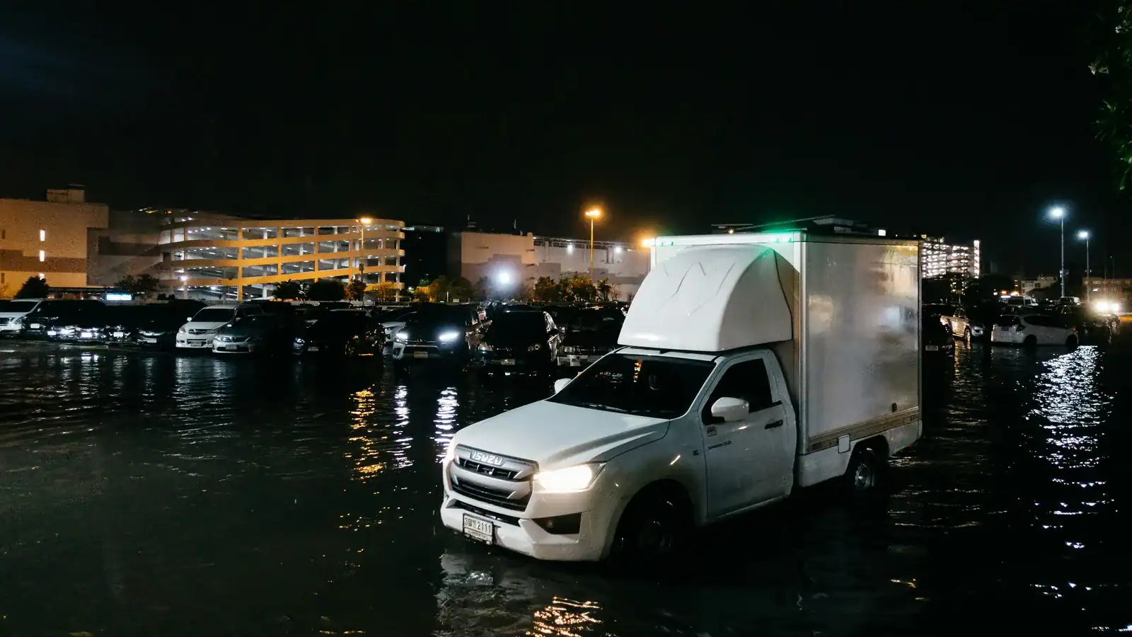 White truck driving through a flooded street