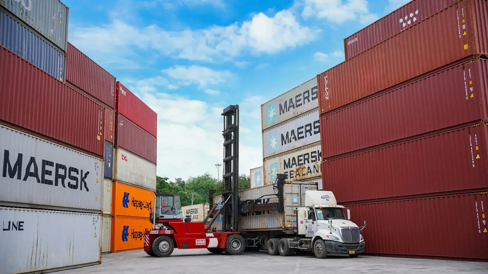 Forklift moving shipping containers at a port