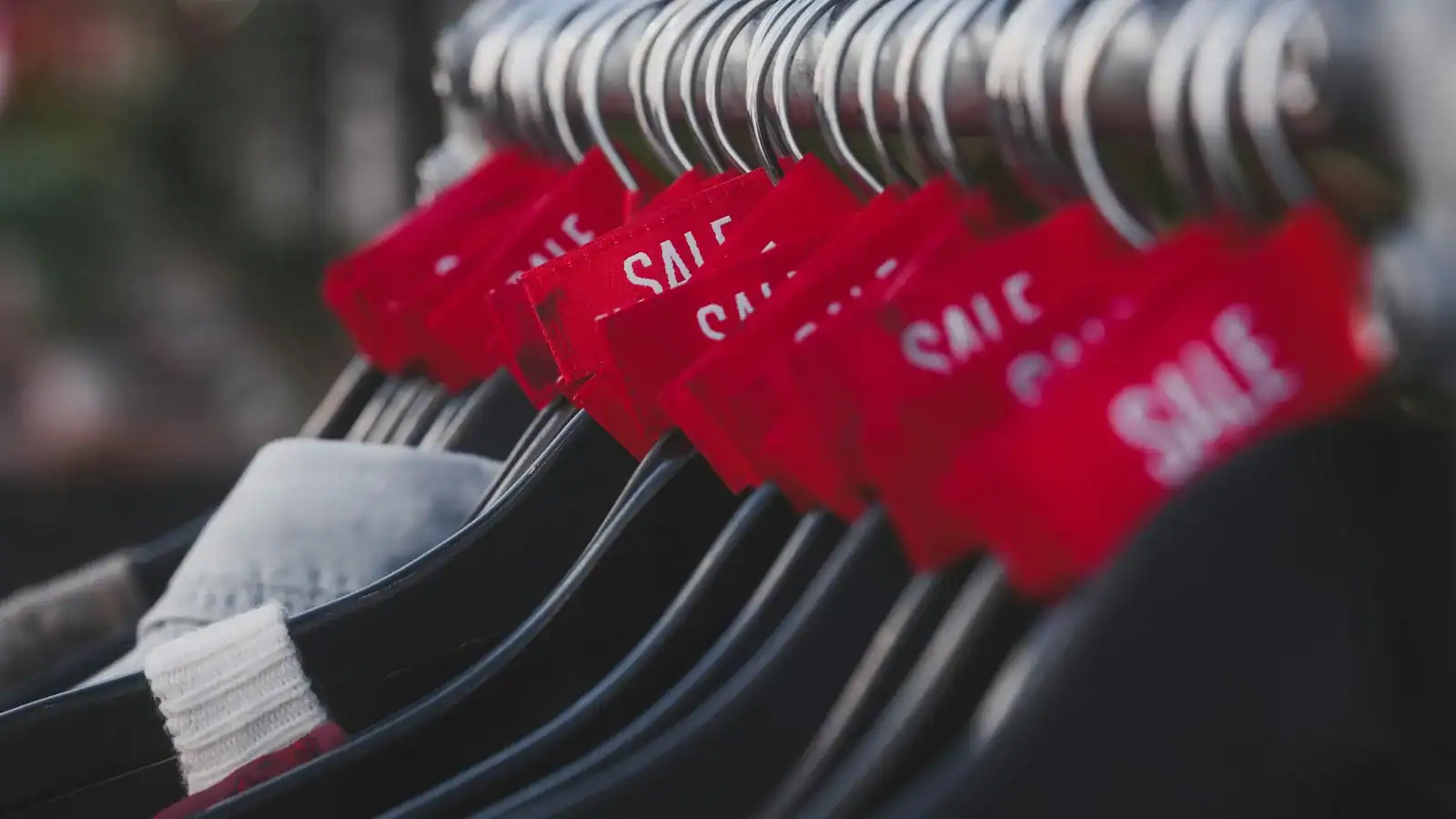 Clothing rack with red sale tags on the hangers