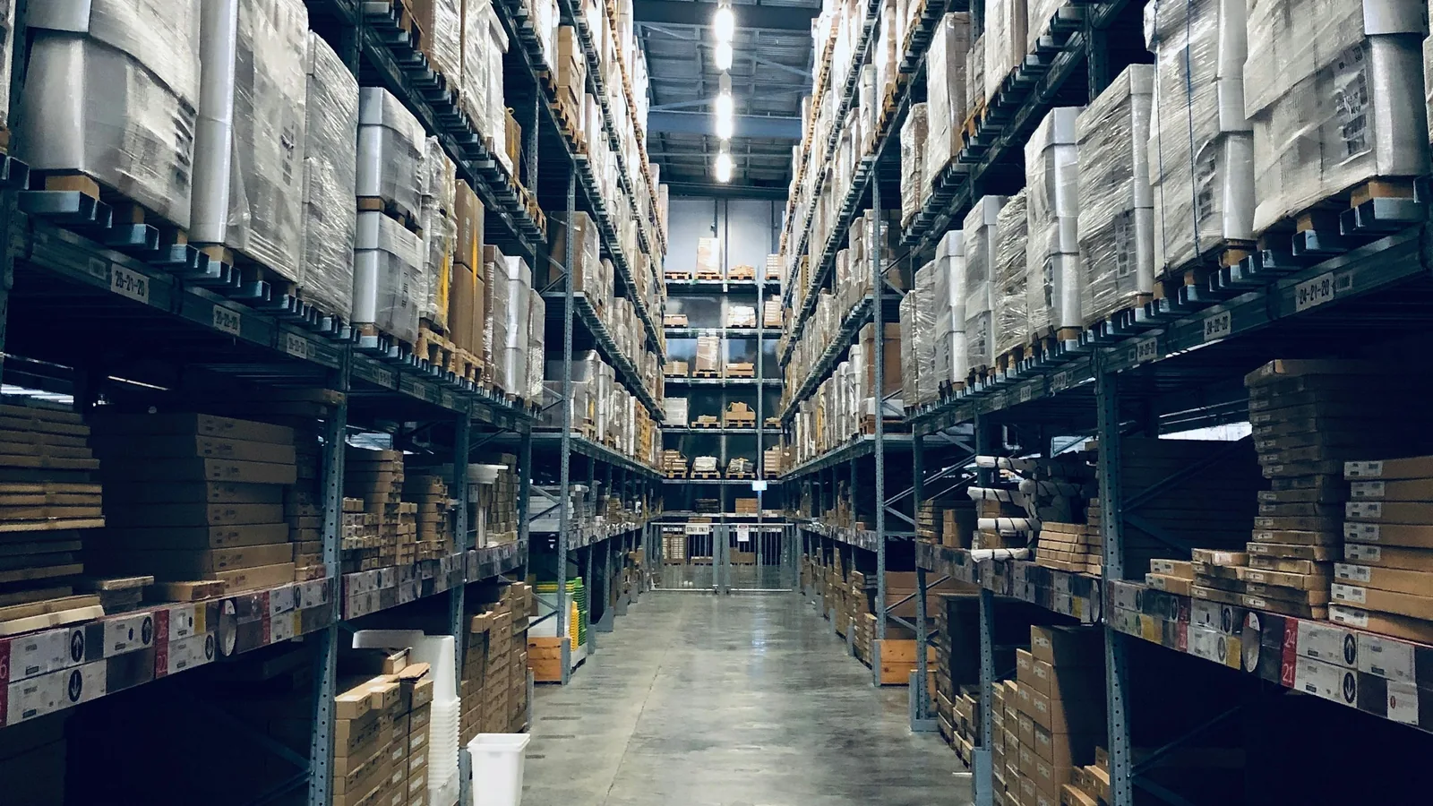 High-bay warehouse aisle with pallet racking full of boxed stock