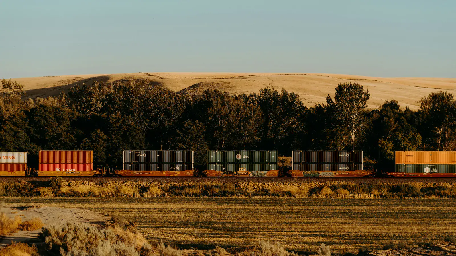 Freight train travelling through a dry rural landscape