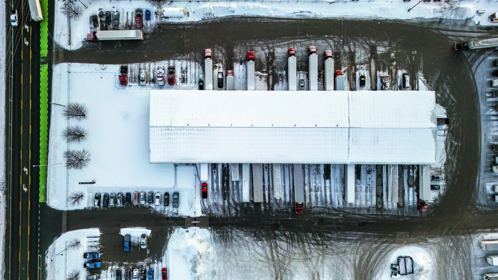 Aerial view of a cross-dock distribution center with trucks backed up to loading doors on both sides